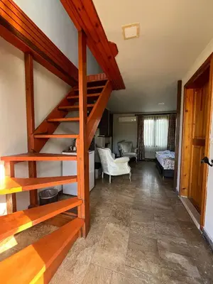 a living room with a spiral staircase in a house at Gizemli Nehir Bungalov Otel in Agva
