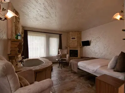 a bedroom with a bed and a tub in a room at Gizemli Nehir Bungalov Otel in Agva
