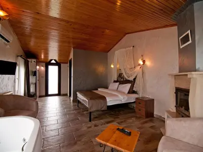 a bedroom with a bed and a fireplace in a room at Gizemli Nehir Bungalov Otel in Agva