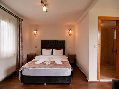 a bedroom with a bed with two towels on it at Gizemli Nehir Bungalov Otel in Agva