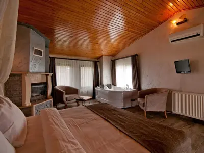a bedroom with a bed and a tub and a sink at Gizemli Nehir Bungalov Otel in Agva