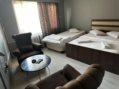 a room with two beds and a couch and a table at Butik Apart in Tekirdag