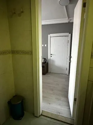 a hallway with a white door and a trash can at Butik Apart in Tekirdag