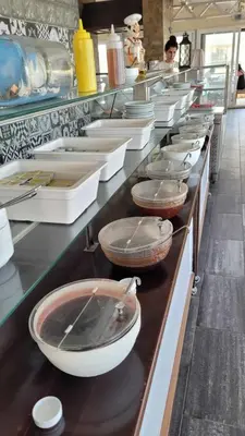a line of bowls and pans on a counter in a kitchen at Yağcı Hotel Erdek in Erdek