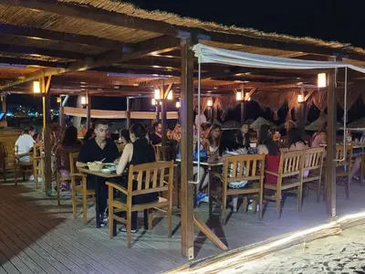 a group of people sitting at tables in a restaurant at Yağcı Hotel Erdek in Erdek