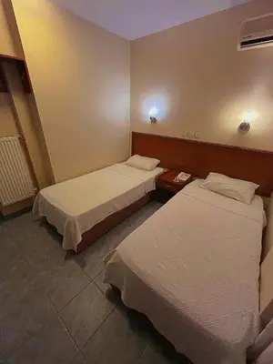 a hotel room with two beds and a table at Yağcı Hotel Erdek in Erdek
