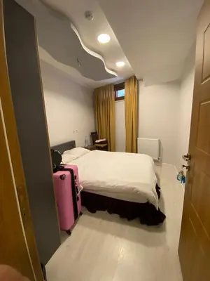 a hotel room with a bed and a pink suitcase at RAMOS İSTANBUL OLD CİTY CENTEr in Istanbul