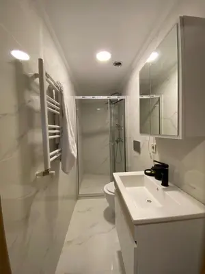 a white bathroom with a shower and a sink at RAMOS İSTANBUL OLD CİTY CENTEr in Istanbul