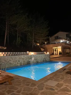 a swimming pool at night with a waterfall at Niceland İznik