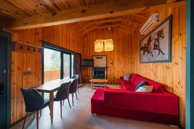 a living room with a red couch and a table at Say Resort Bungalov in Sapanca
