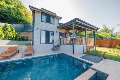 a house with a swimming pool in front of a house at Say Resort Bungalov in Sapanca
