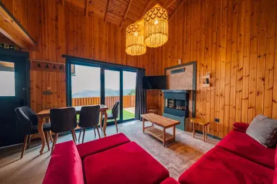 a living room with a red couch and a table at Say Resort Bungalov in Sapanca