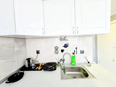 a kitchen counter with a sink and white cabinets at Taksim Luxury Capital Hotel in Istanbul