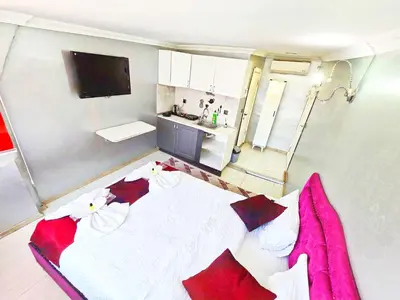 a bedroom with a large white bed with red pillows at Taksim Luxury Capital Hotel in Istanbul