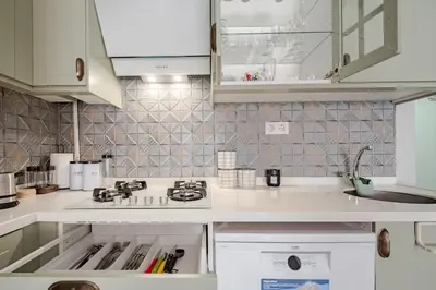a kitchen with white cabinets and a stove top oven at Kadıköy ün Kalbinde Tarihi Rahat Sessiz Daire in Istanbul