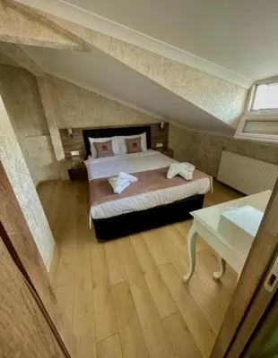 a attic bedroom with a bed and a table at elegance famıly house in Istanbul