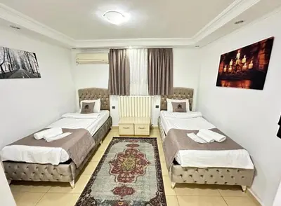 a hotel room with two beds and a rug at elegance famıly house in Istanbul