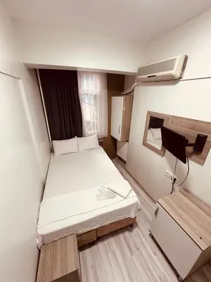 a small room with a bed and a fan at Sera Hotel in Istanbul