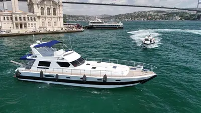 a white boat in the water near a bridge at Pruva Yacht in Istanbul