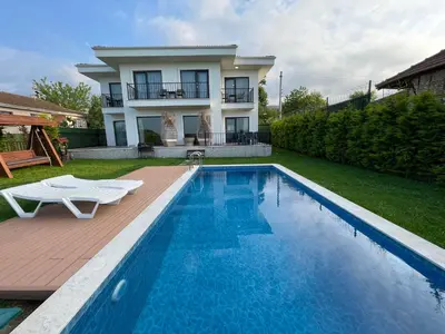 a villa with a swimming pool in front of a house at Sakarya Sapanca Ünlüce de 5 oda 1 salon Özel Havuzlu Lux 10 kişilik Tatil Villası in Sapanca