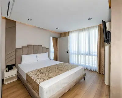 a bedroom with a large bed and a television at Hilltown Airport Hotel & Restaurant in Taşoluk