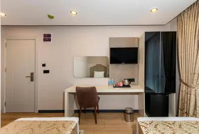 a room with a desk and a table with a chair at Hilltown Airport Hotel & Restaurant in Taşoluk