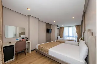 a hotel room with a bed and a desk at Hilltown Airport Hotel & Restaurant in Taşoluk