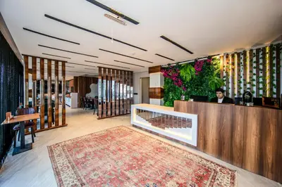 a lobby with a person sitting at a counter at Hilltown Airport Hotel & Restaurant in Taşoluk