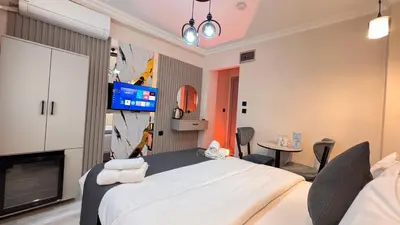 a bedroom with a large white bed and a tv at Mar Blanco Hotel in Istanbul