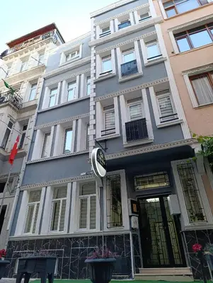 a gray building with a clock in front of it at King Mas Suit in Istanbul