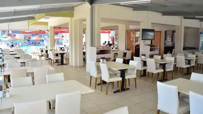 a dining room with white tables and white chairs at Sare Hotel in Erdek