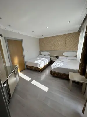 a room with three beds and a television in it at ORAL hotel in Istanbul