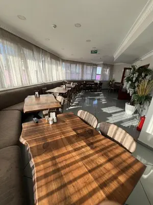 a restaurant with wooden tables and chairs in a room at ORAL hotel in Istanbul