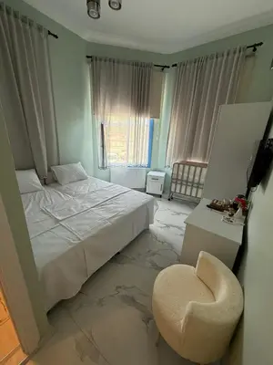 a bedroom with a white bed and a chair at Meydan 76 in Adalar