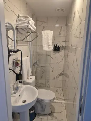 a white bathroom with a toilet and a sink at Meydan 76 in Adalar