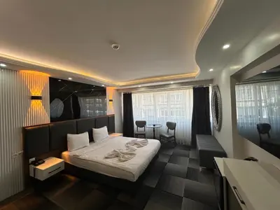 a hotel room with a bed and a table and chairs at Lizbonia Suit in Istanbul