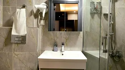 a bathroom with a sink and a shower with a mirror at Lizbonia Suit in Istanbul