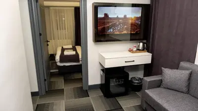 a room with a tv and a couch and a mirror at Lizbonia Suit in Istanbul