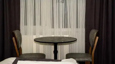 a table and chairs in a room with curtains at Lizbonia Suit in Istanbul