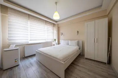a bedroom with a large white bed and a window at White Rose Apartments in Istanbul