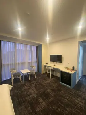 a hotel room with a desk and chairs and a tv at No25 Hotels in Corlu