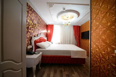 a bedroom with a bed with red curtains and a window at Fatih Babel Park Hotel in Istanbul