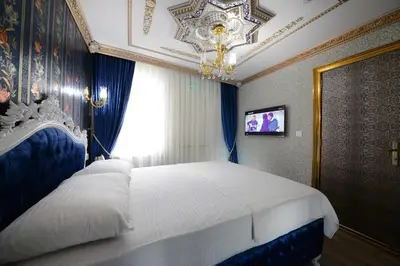 a bedroom with a large bed with a chandelier at Fatih Babel Park Hotel in Istanbul