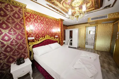 a bedroom with a large white bed and a chandelier at Fatih Babel Park Hotel in Istanbul