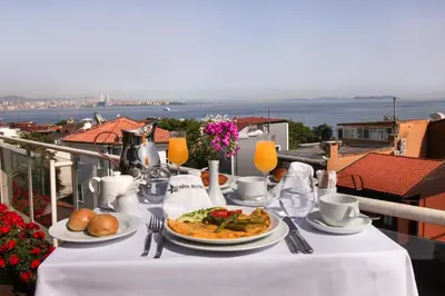 a table with a plate of food on a balcony at Almina Guest House in Istanbul