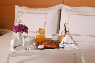 a breakfast tray with a croissant on a bed at Almina Guest House in Istanbul