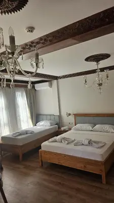 a bedroom with two beds and a chandelier at Duru Hanım Konağı in Mudanya