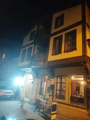 a yellow and white building with a table in front of it at Duru Hanım Konağı in Mudanya