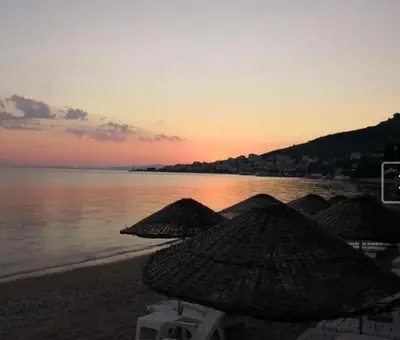 a group of umbrellas on the beach at sunset at boncuk motel in Marmara