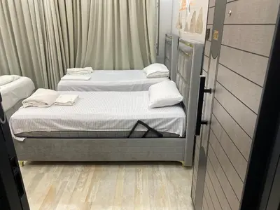 two twin beds in a small room with wood floors at lastbest hotel in Istanbul